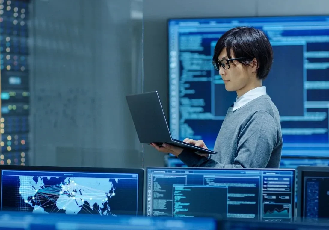 A tech personnel using a laptop